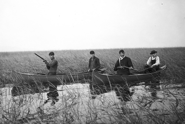 Indigenous guides in canoes