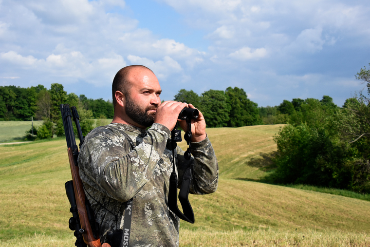 hunter hold binoculars looking for groundhogs