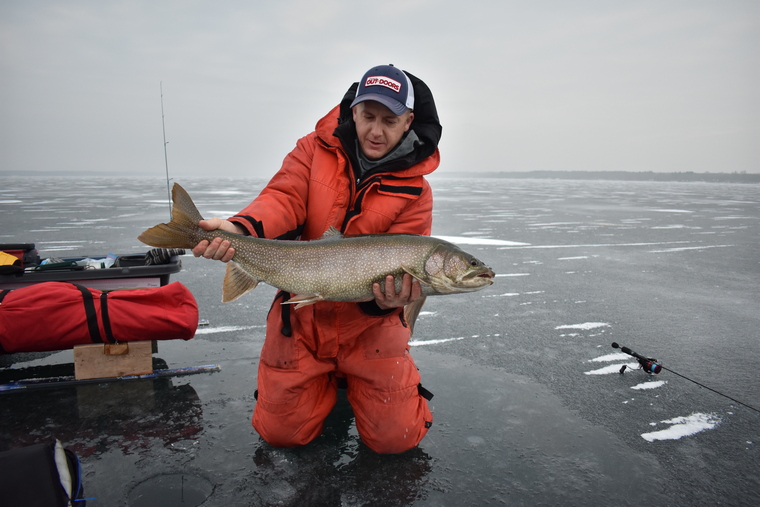 ice angler holds lake trout 
