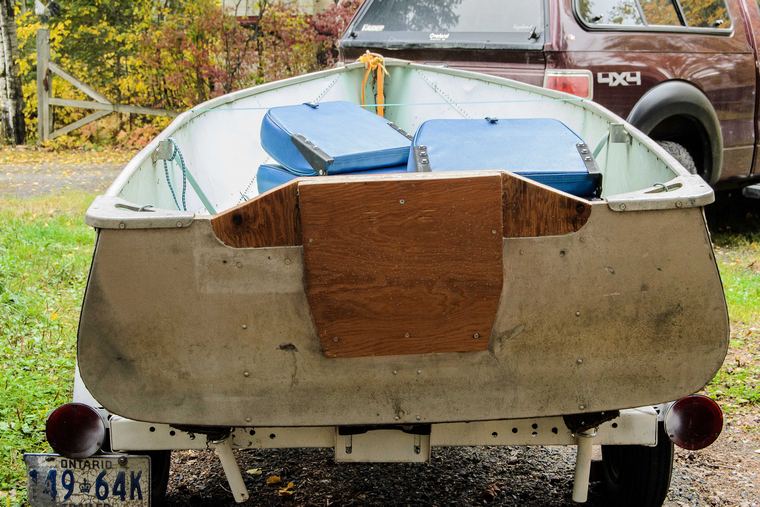 back of a tin boat with repaired plywood transom being towed.