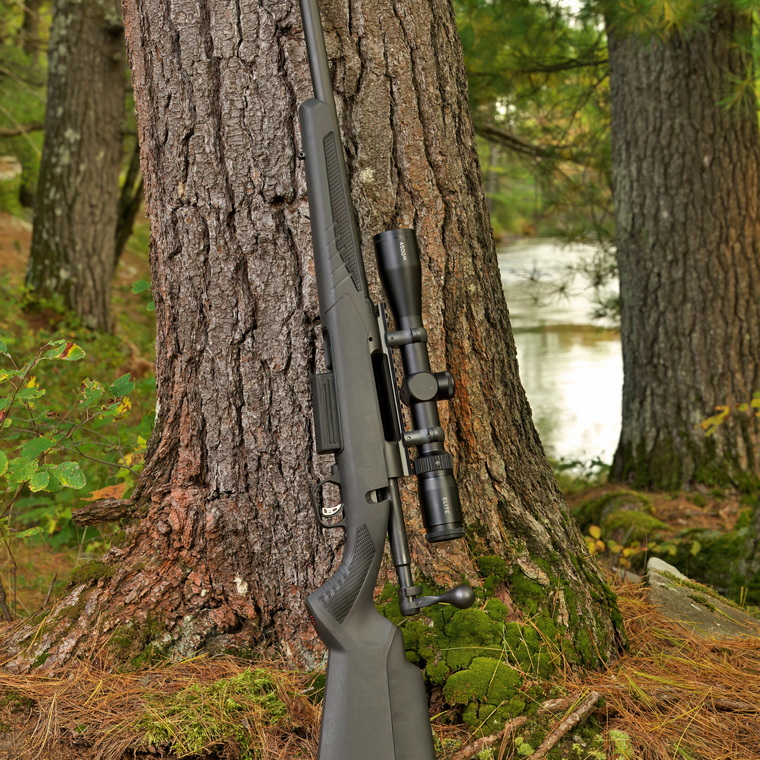 A bolt-action shotgun against a tree