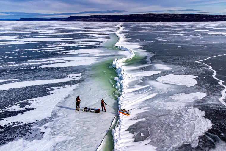 two angler on the ice crossing a pressure crack
