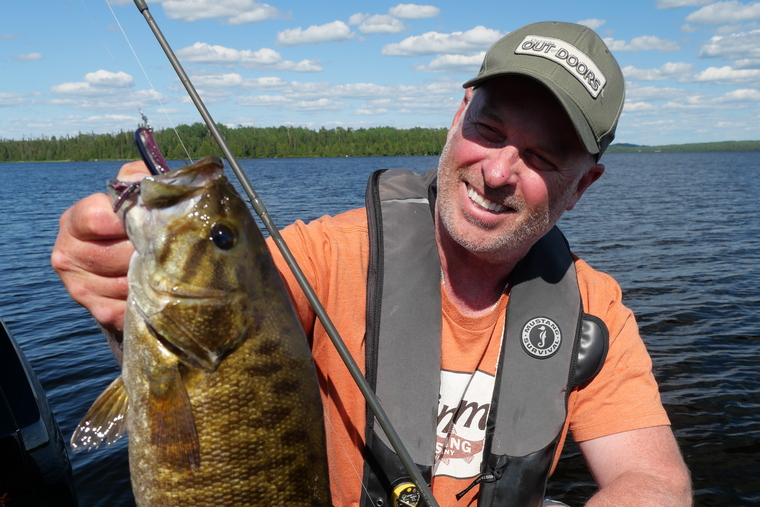 angler holding smallmouth bass with tube