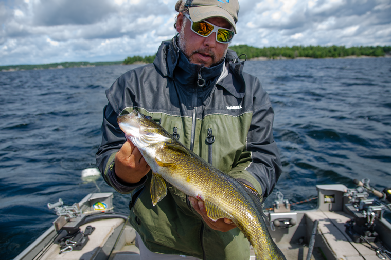 Angler with a walleye caught when using a drag bucket